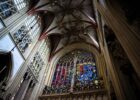 Intérieur d’une église gothique aux vitraux colorés et voûte décorée
