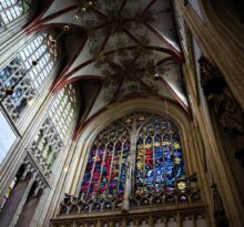 Intérieur d’une église gothique aux vitraux colorés et voûte décorée